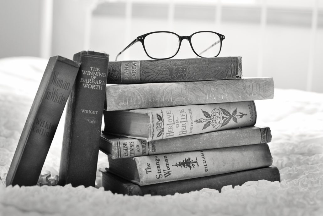 Stack of vintage books with glasses