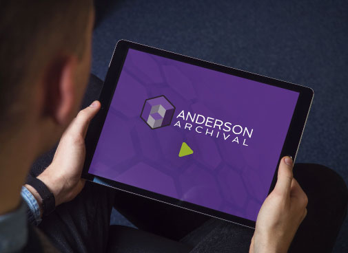 Man looking at tablet with Anderson Archival logo on it